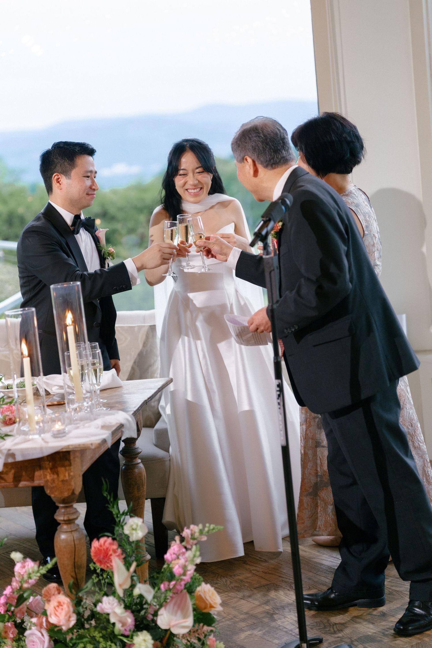 Bride and groom toasting champagne with elderly guests at a beautifully decorated wedding reception.