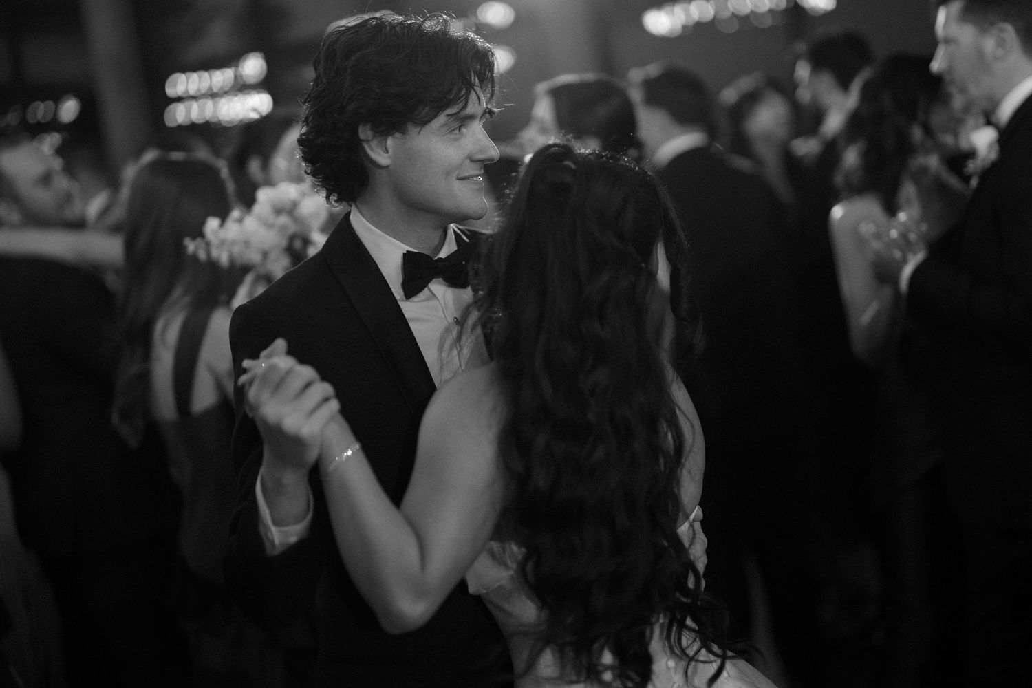 Black and white romantic first dance photo of bride and groom at wedding reception.