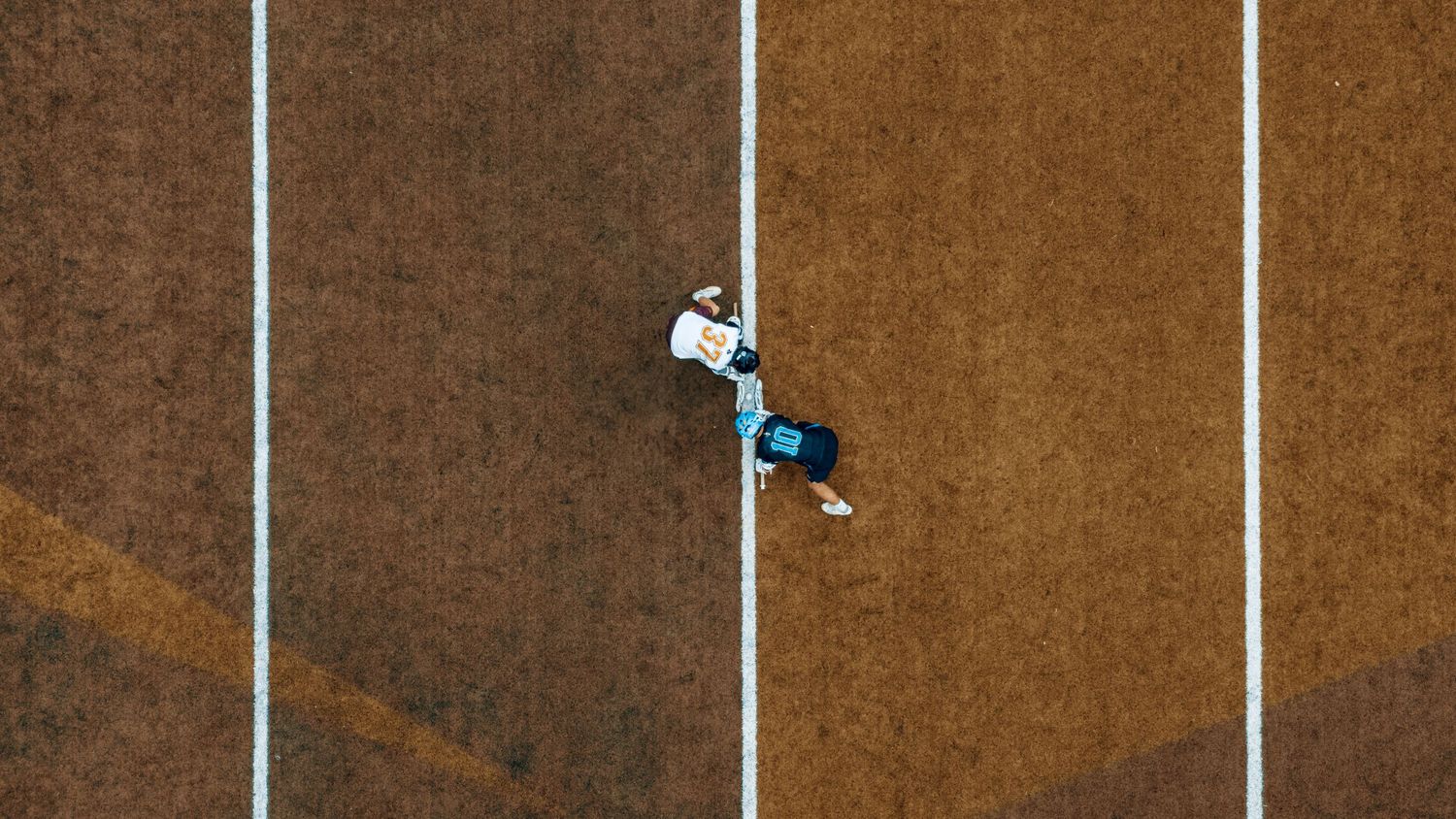Drone image of CAK and USN mens lacrosse teams facing off