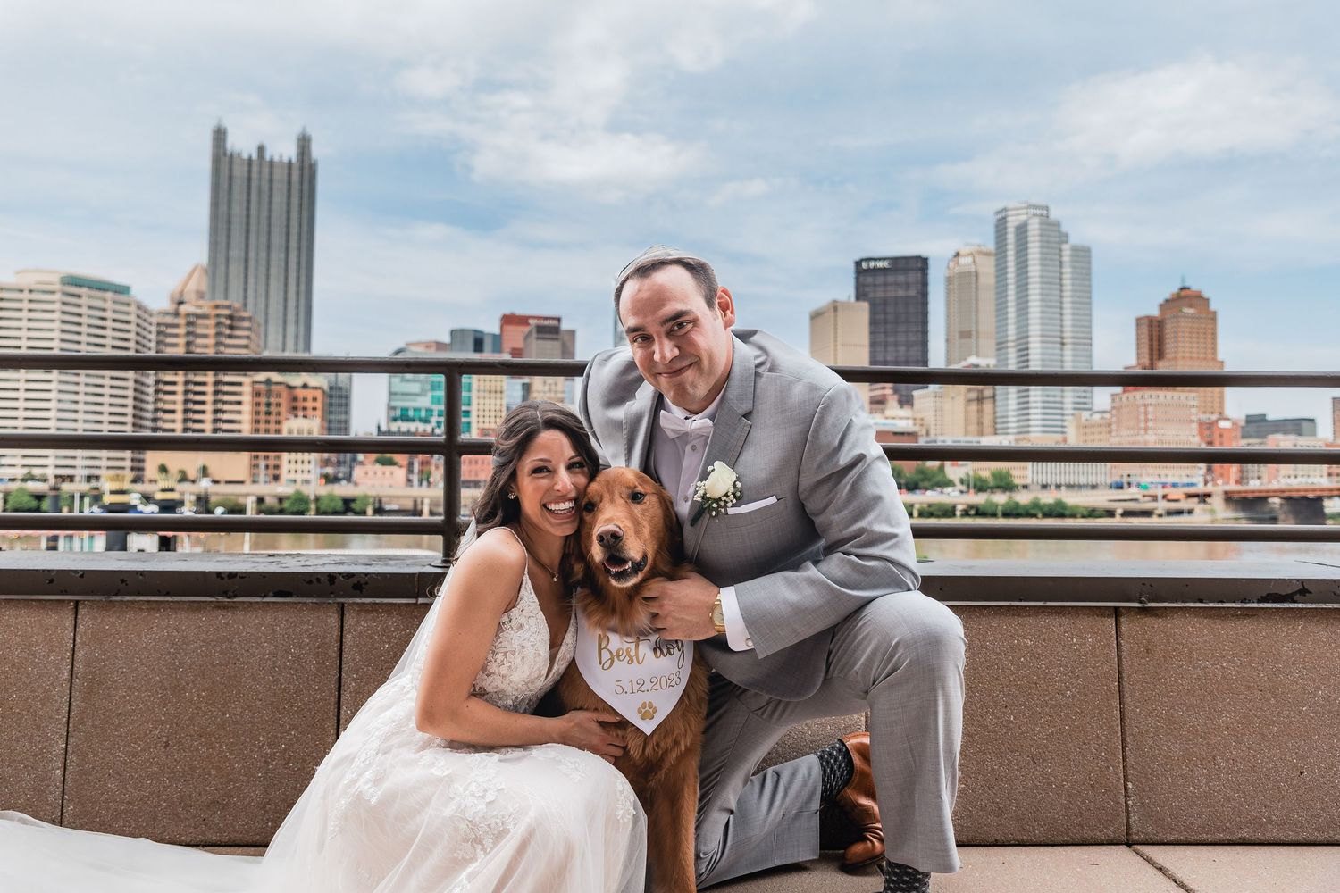 A couple shares joyful moments on a rooftop with the city skyline in the background during a photo session.