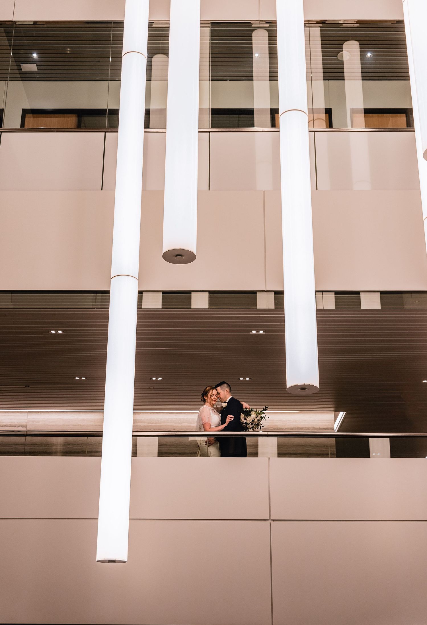 Modern architectural interior with white columns and balconies creating geometric lines and minimalist aesthetic.