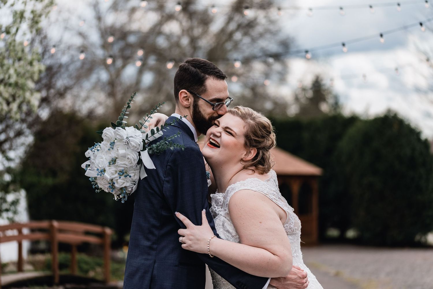 Joyful celebration at an outdoor ceremony with string lights overhead.