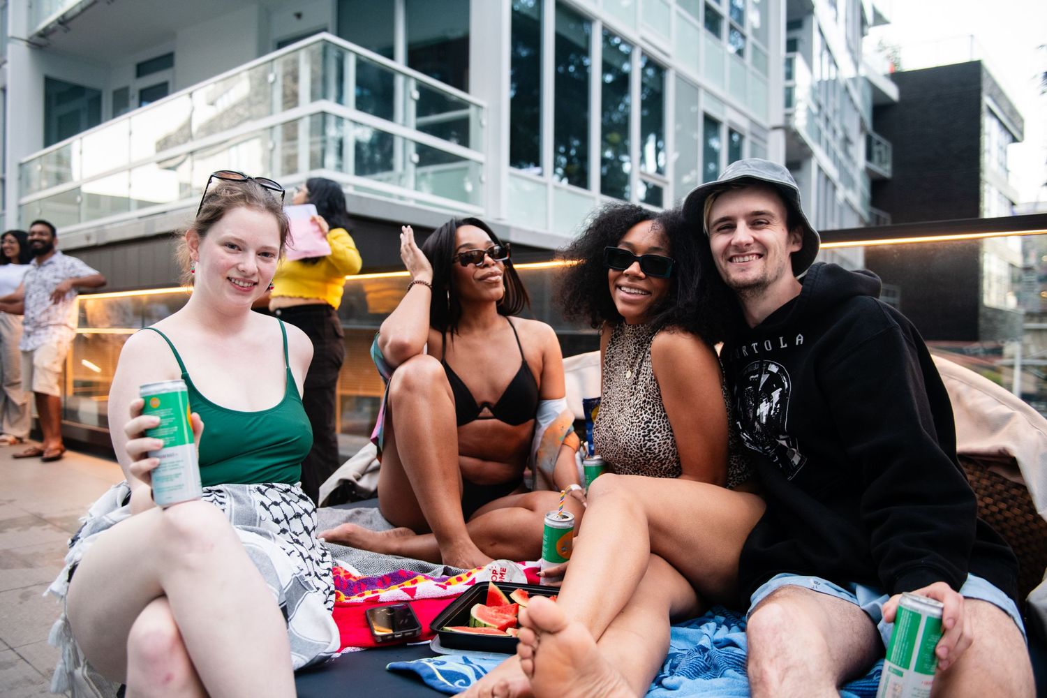 Friends relax on pool chairs during a summer party at an apartment complex.