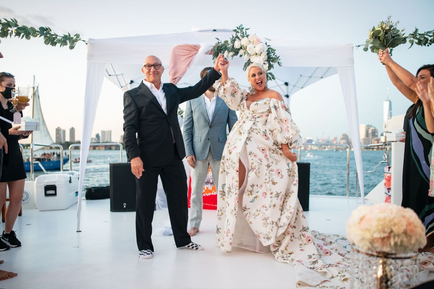 Newlyweds celebrate with guests on decorated waterfront venue.