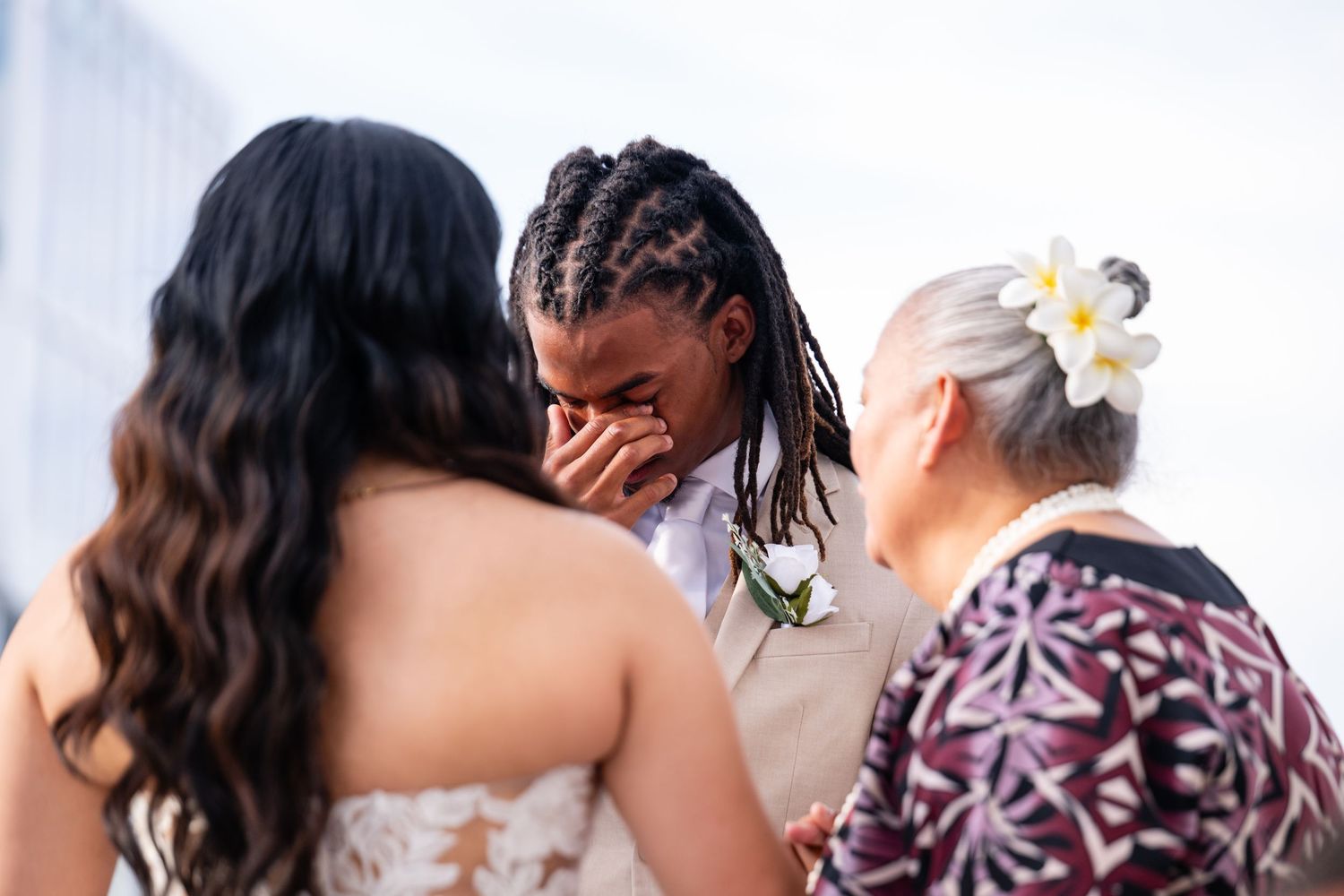 Wedding guests enjoying an outdoor celebration near the ocean with blue sky backdrop.