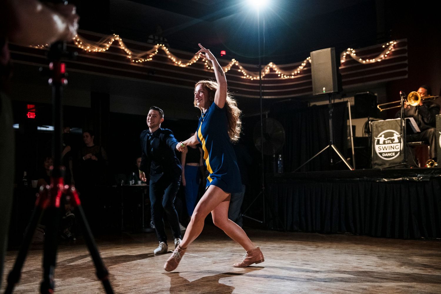 Dancers executing an impressive aerial dance move during a swing performance.