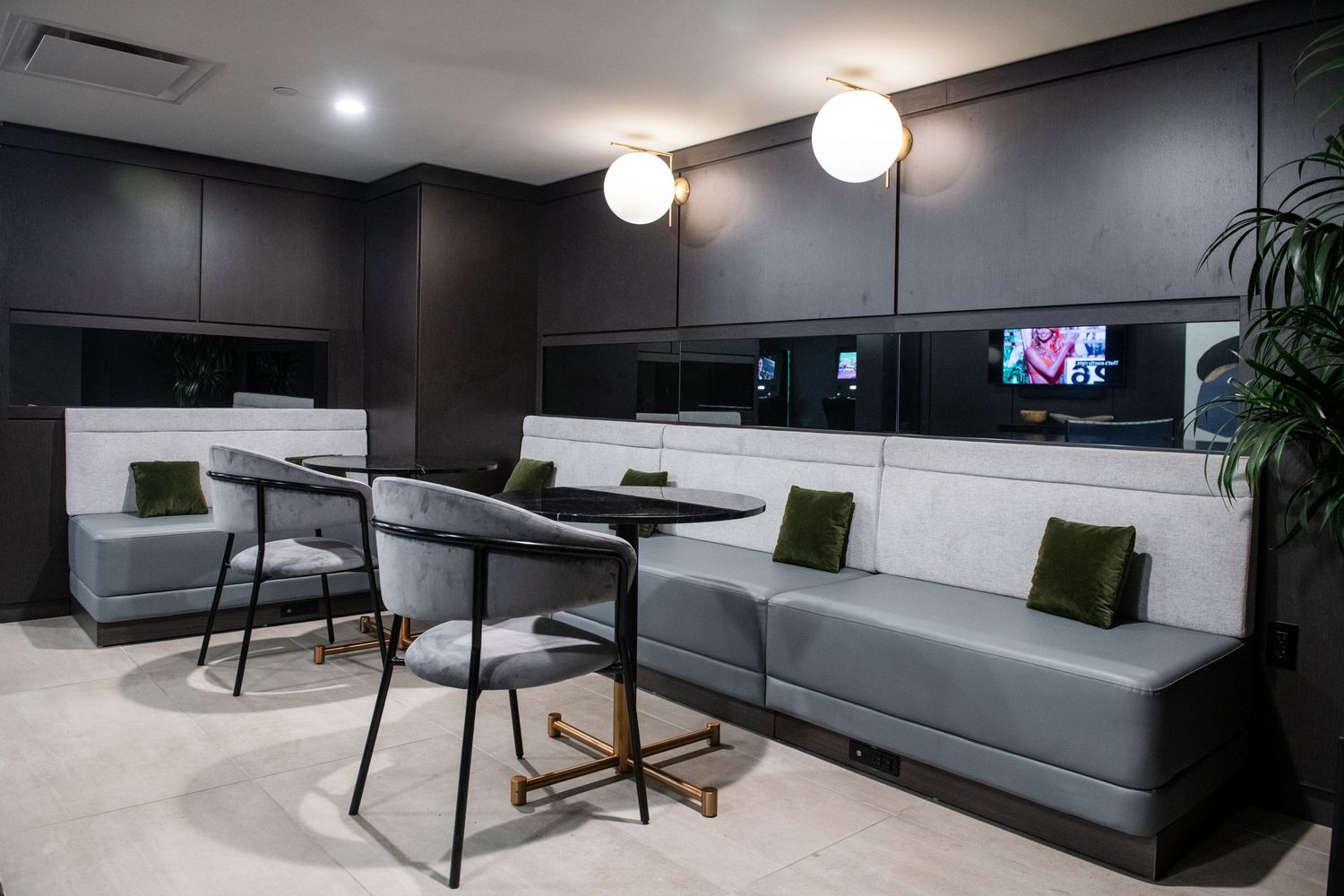 Modern coworking space with built-in seating, dark walls and minimalist decor.