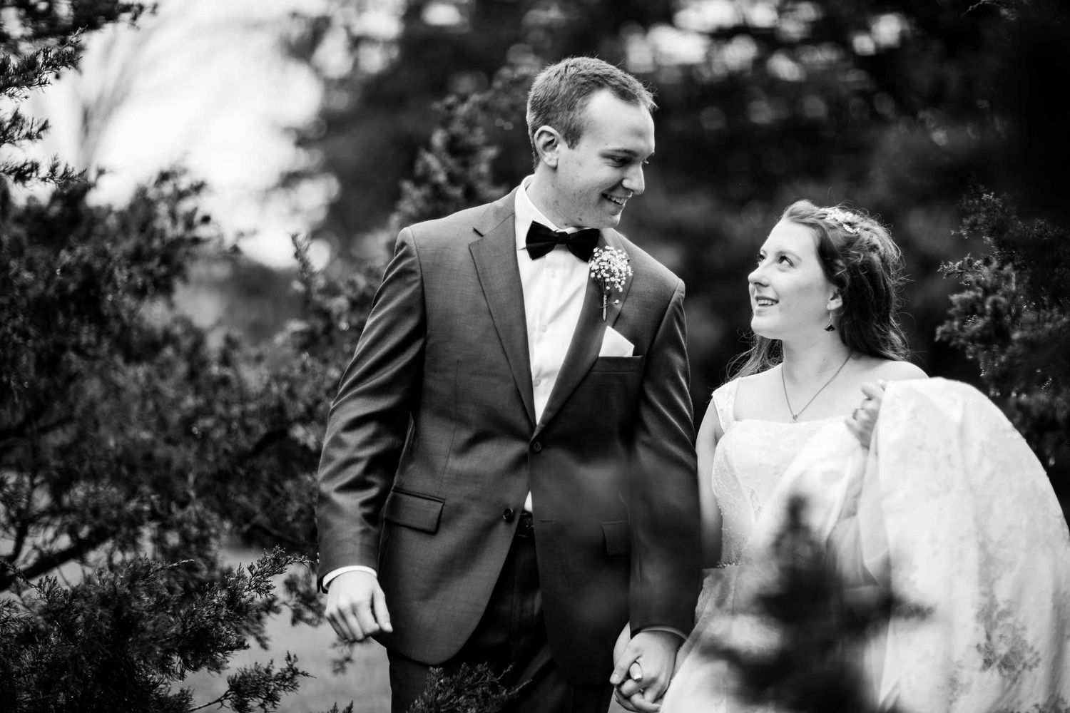 Black and white wedding portrait capturing a joyful moment outdoors.