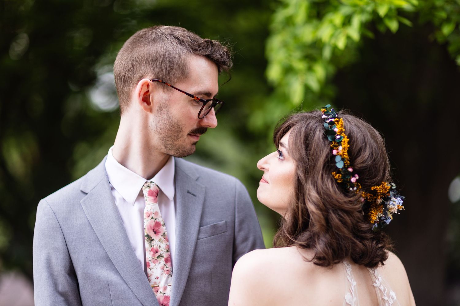 Elegant wedding portrait with couple in gray suit and floral accessories.