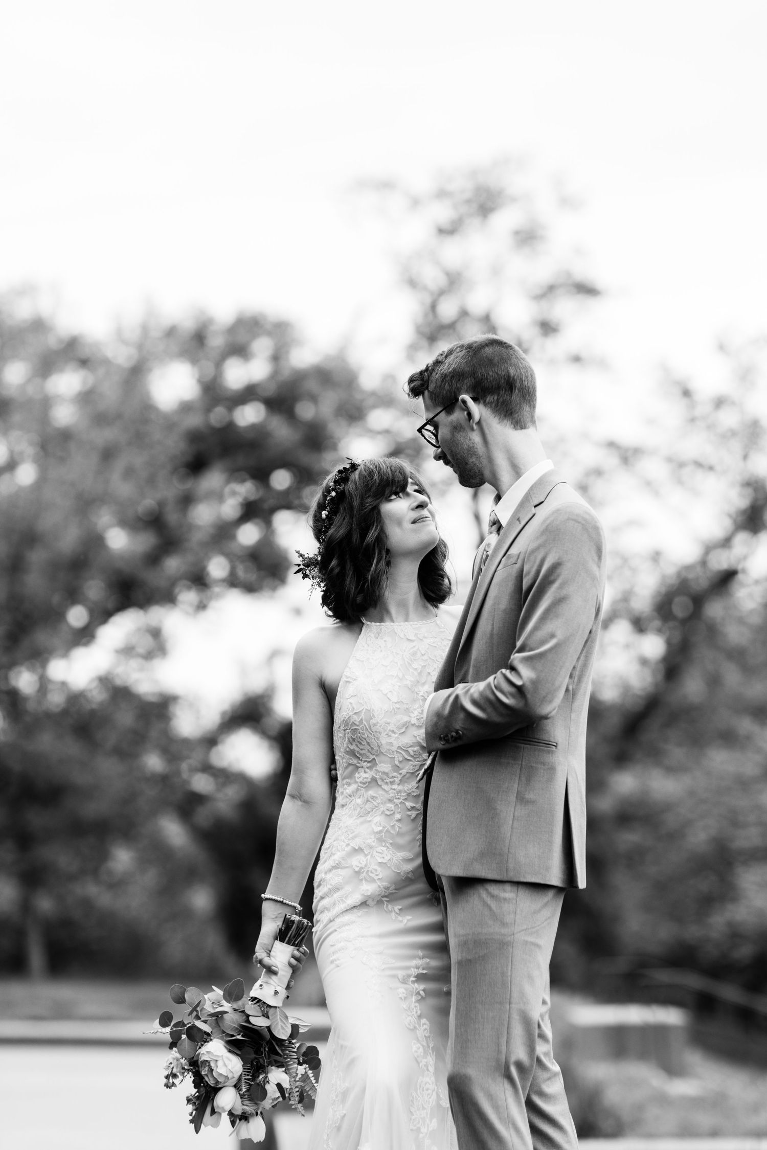 Black and white romantic portrait of wedding couple embracing outdoors.