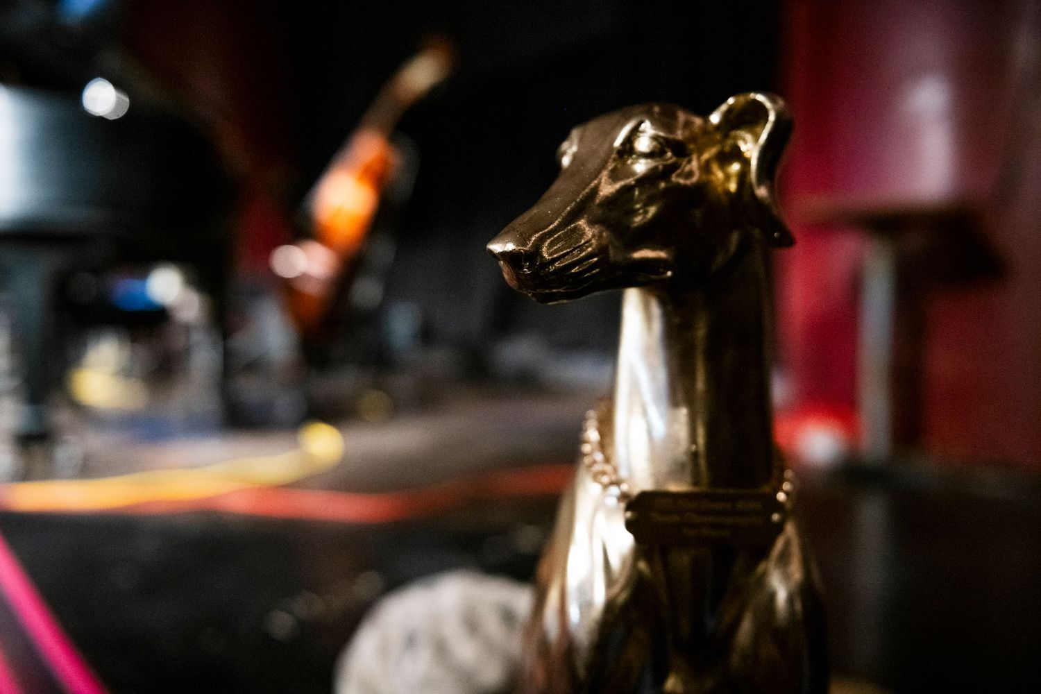 Close-up of a decorative metallic horse head figure with stage lights in the background.