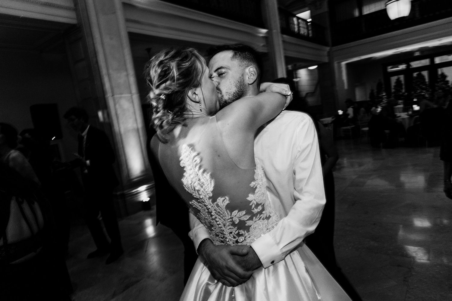 An intimate black and white portrait of a wedding couple sharing a romantic dance moment.
