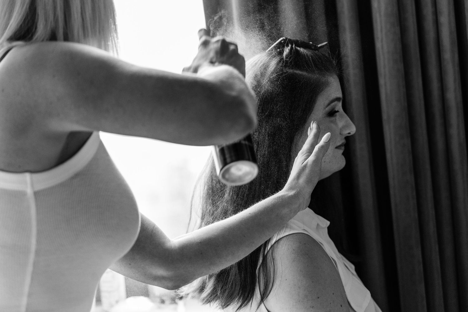 Black and white image of wedding day hair styling preparation.