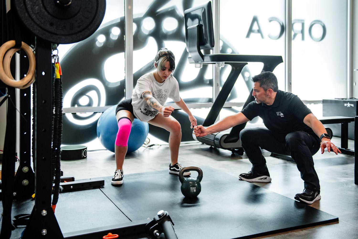 Training session with kettlebell exercise demonstration in a modern fitness facility.