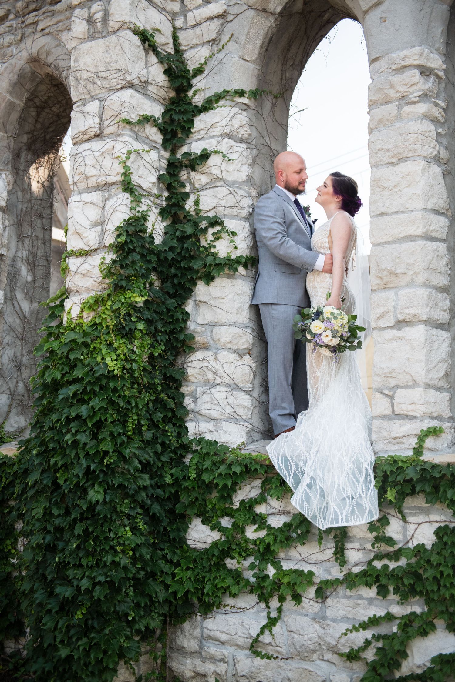 Romantic portrait in stone archway with ivy climbing the historic architecture.