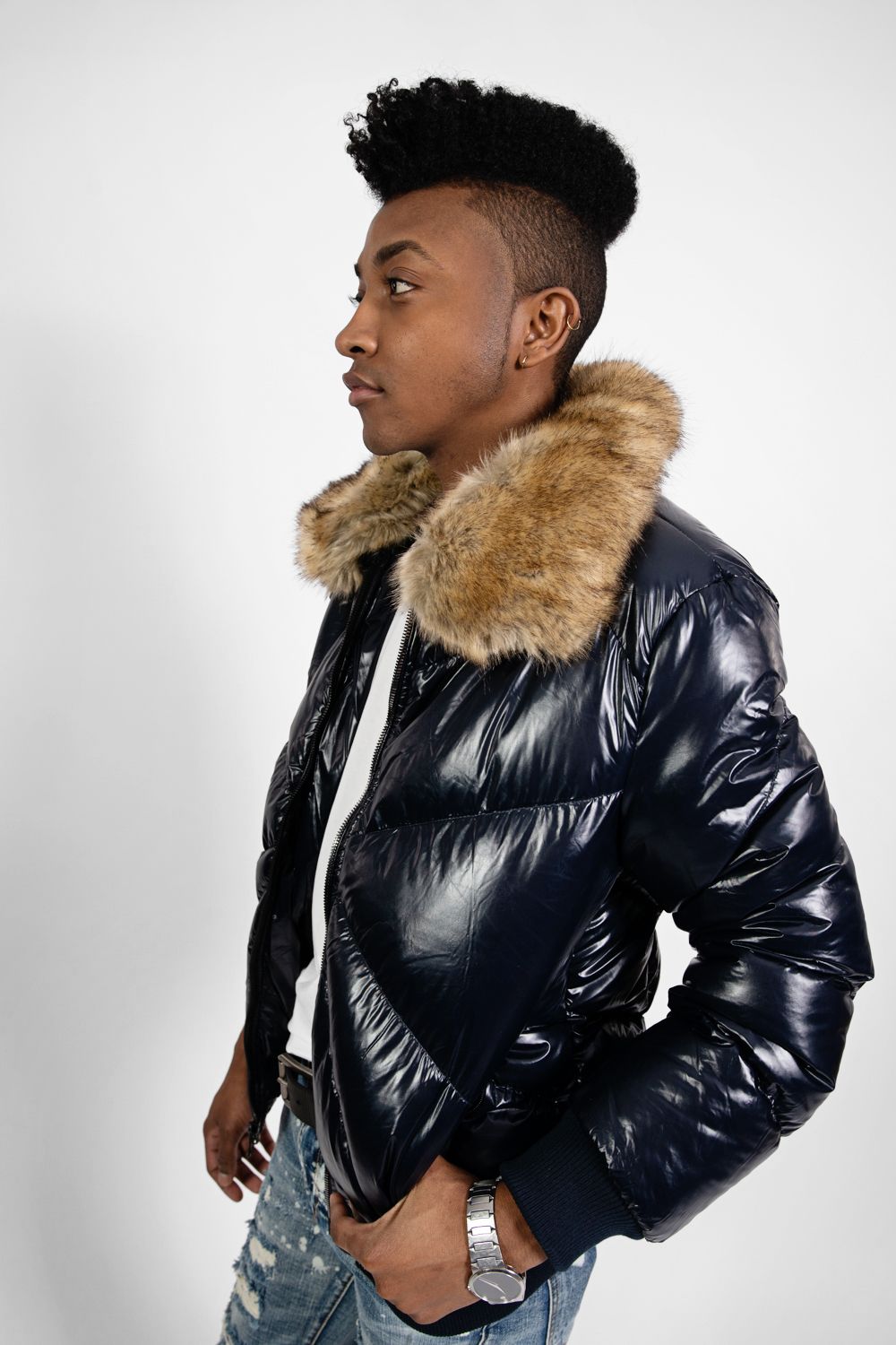 Sleek black puffer jacket with faux fur collar shown in profile against white background.