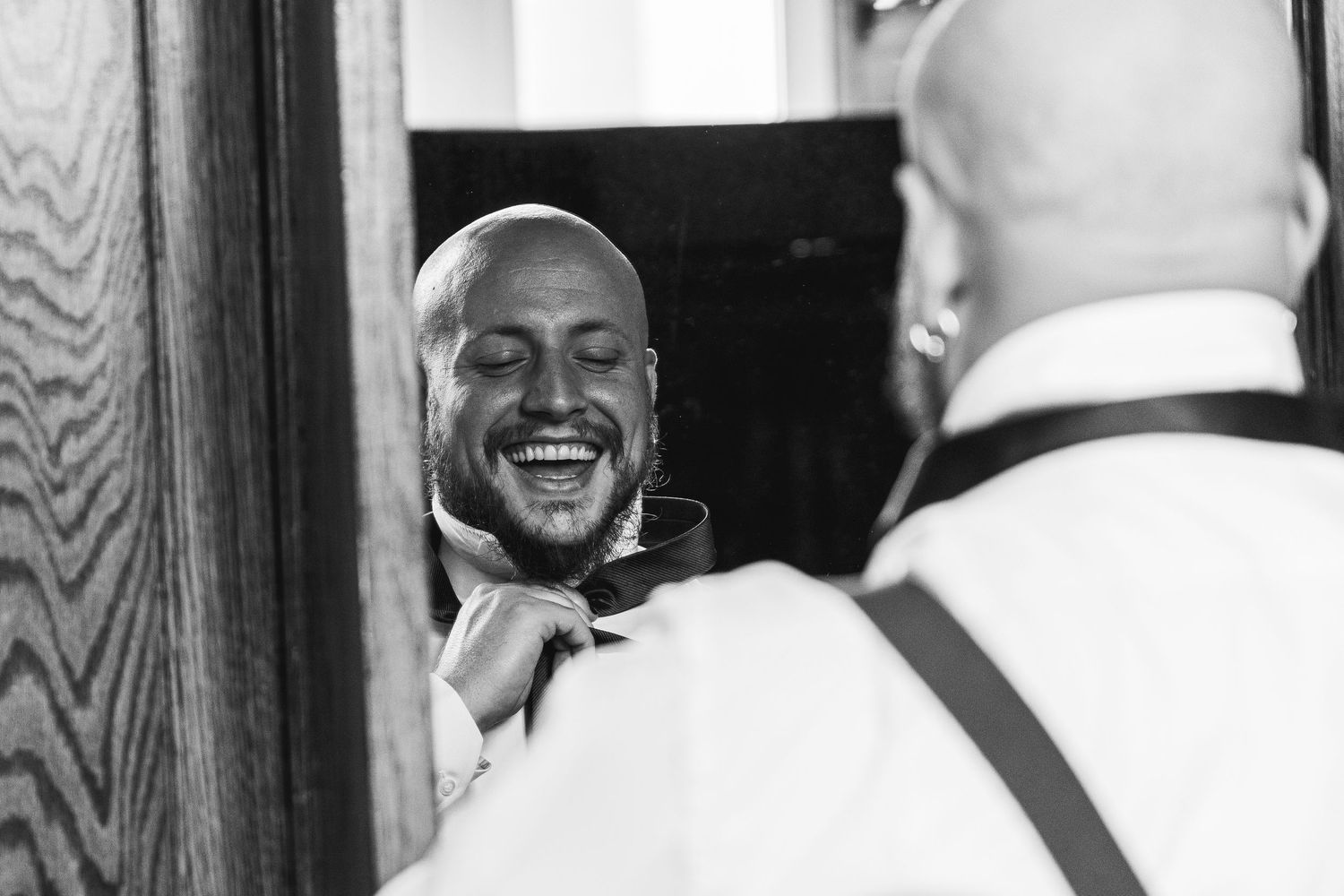 Black and white reflection of a joyful expression in a mirror.