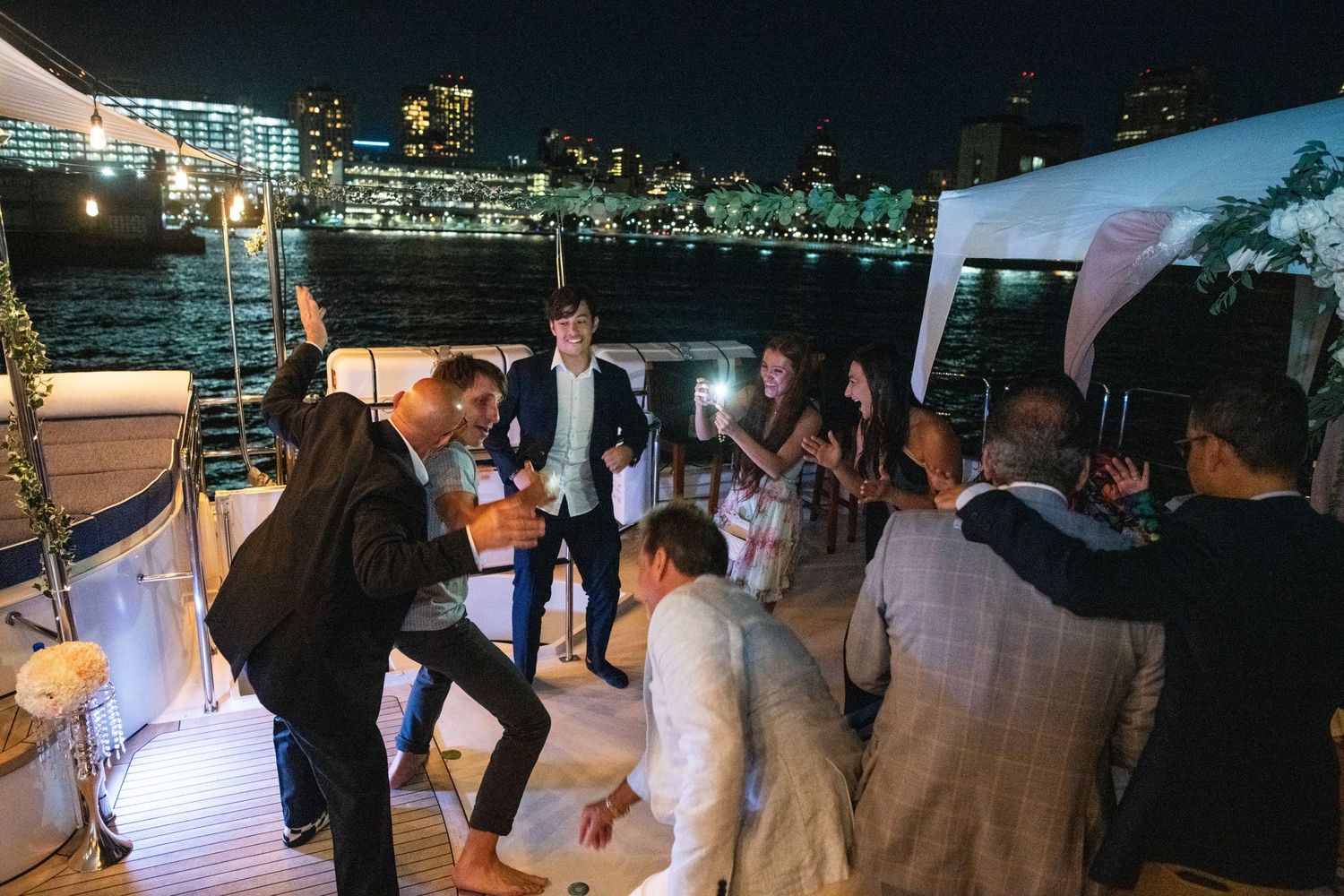 Energetic dance party at night with guests showing off their moves under string lights.
