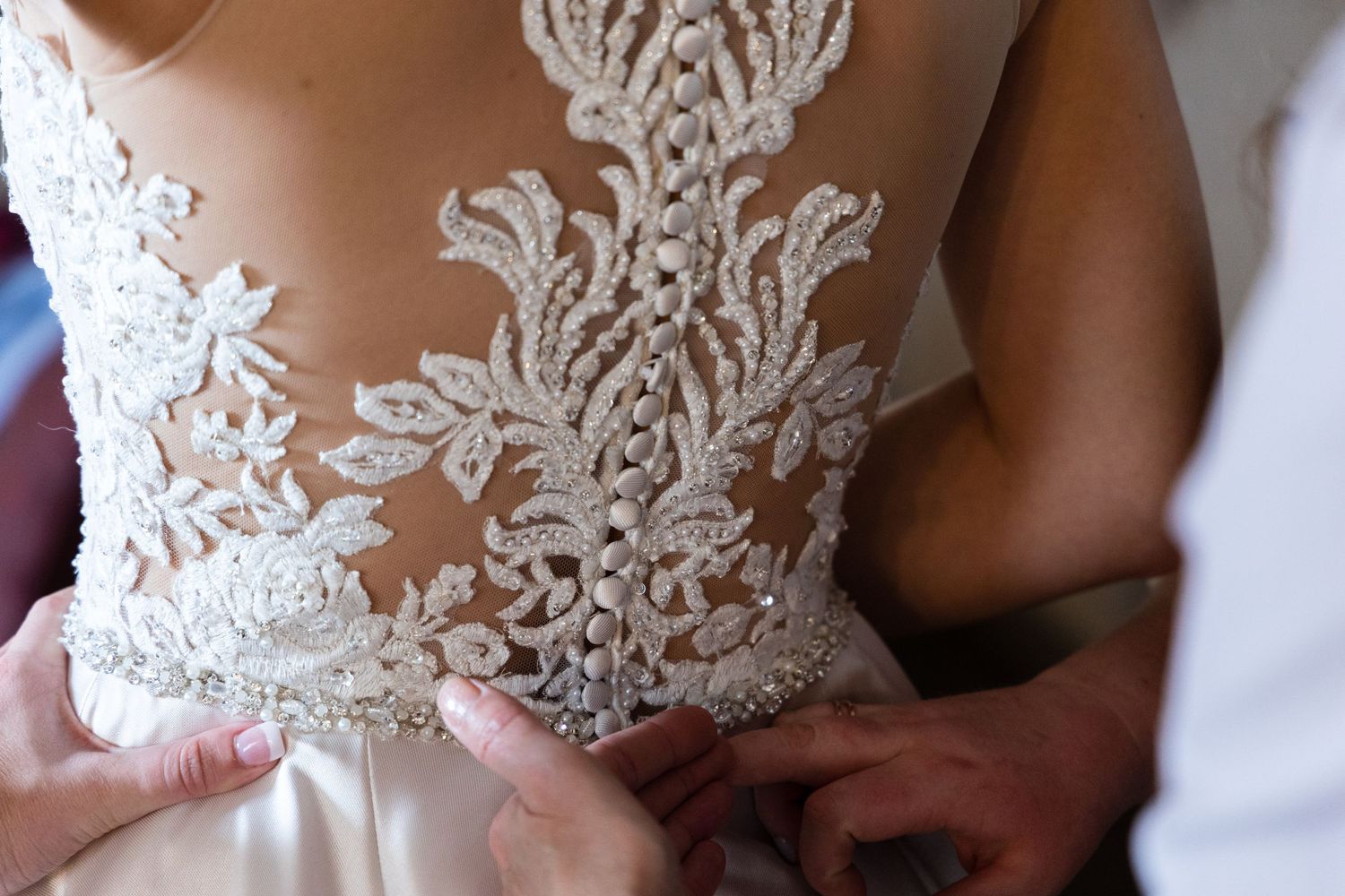 Close-up of intricate lace detail on back of wedding dress.