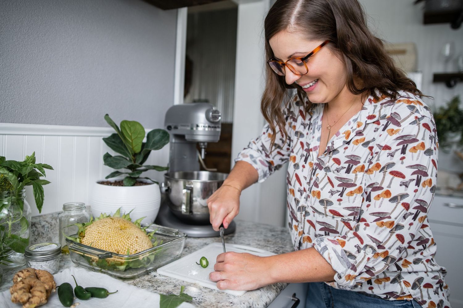 Someone in a patterned shirt preparing ingredients in a modern kitchen.