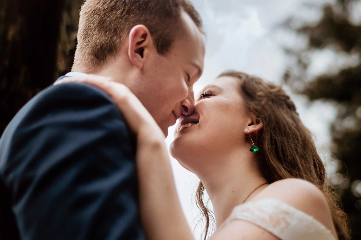 Intimate wedding portrait of a couple sharing a romantic kiss.