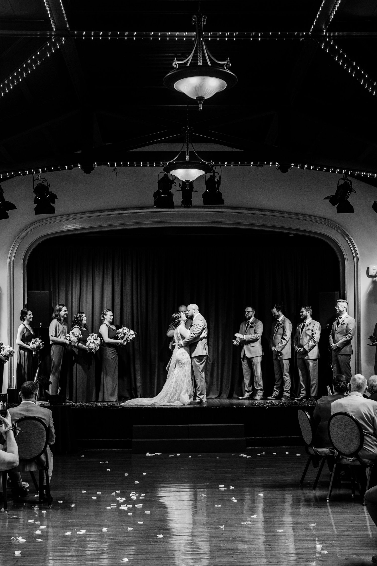 Wedding ceremony in a historic theater venue with ornate lighting and architecture.