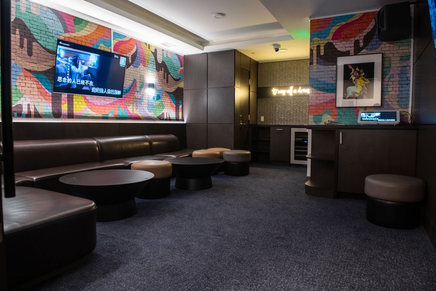 Colorful mural wall in lounge area with curved booth seating and ambient lighting.