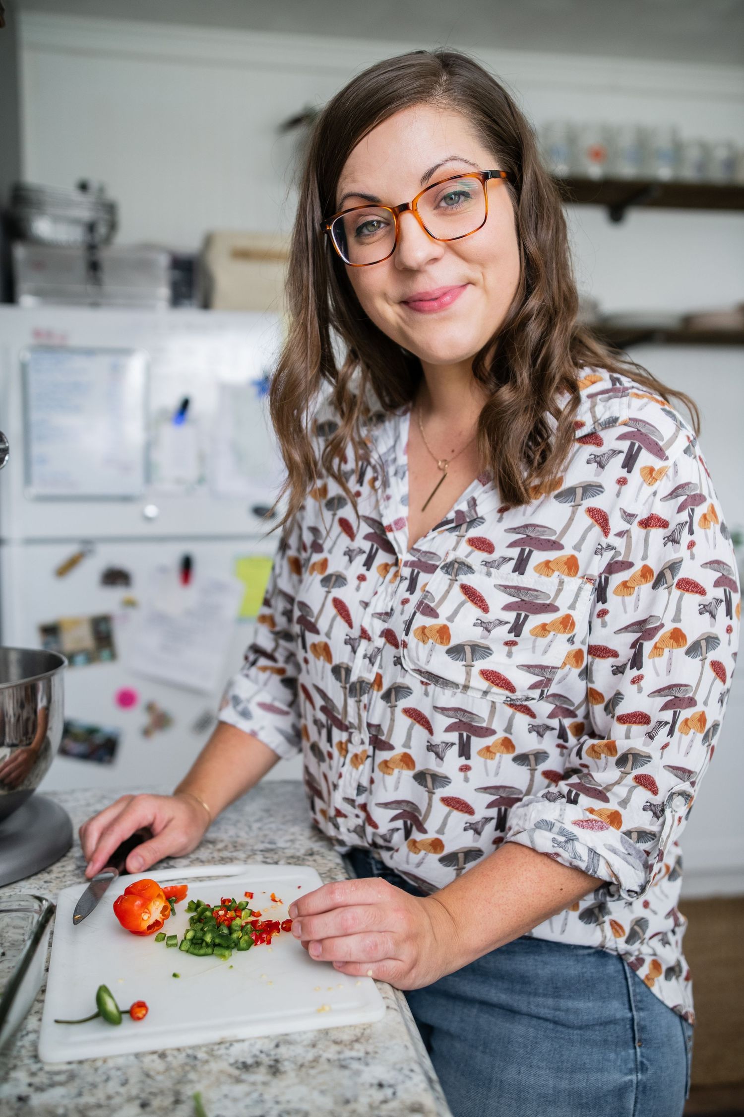 Cook wearing a fox-patterned shirt working in a bright kitchen.