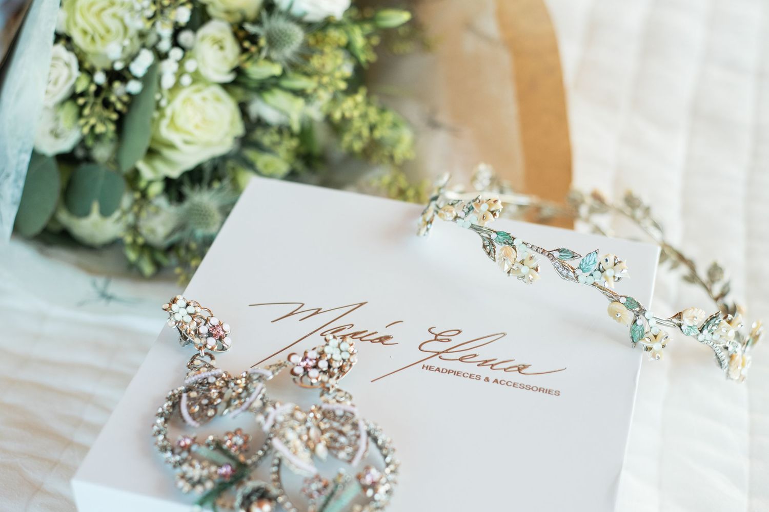 Wedding invitation with delicate floral crown and bouquet details in soft lighting.