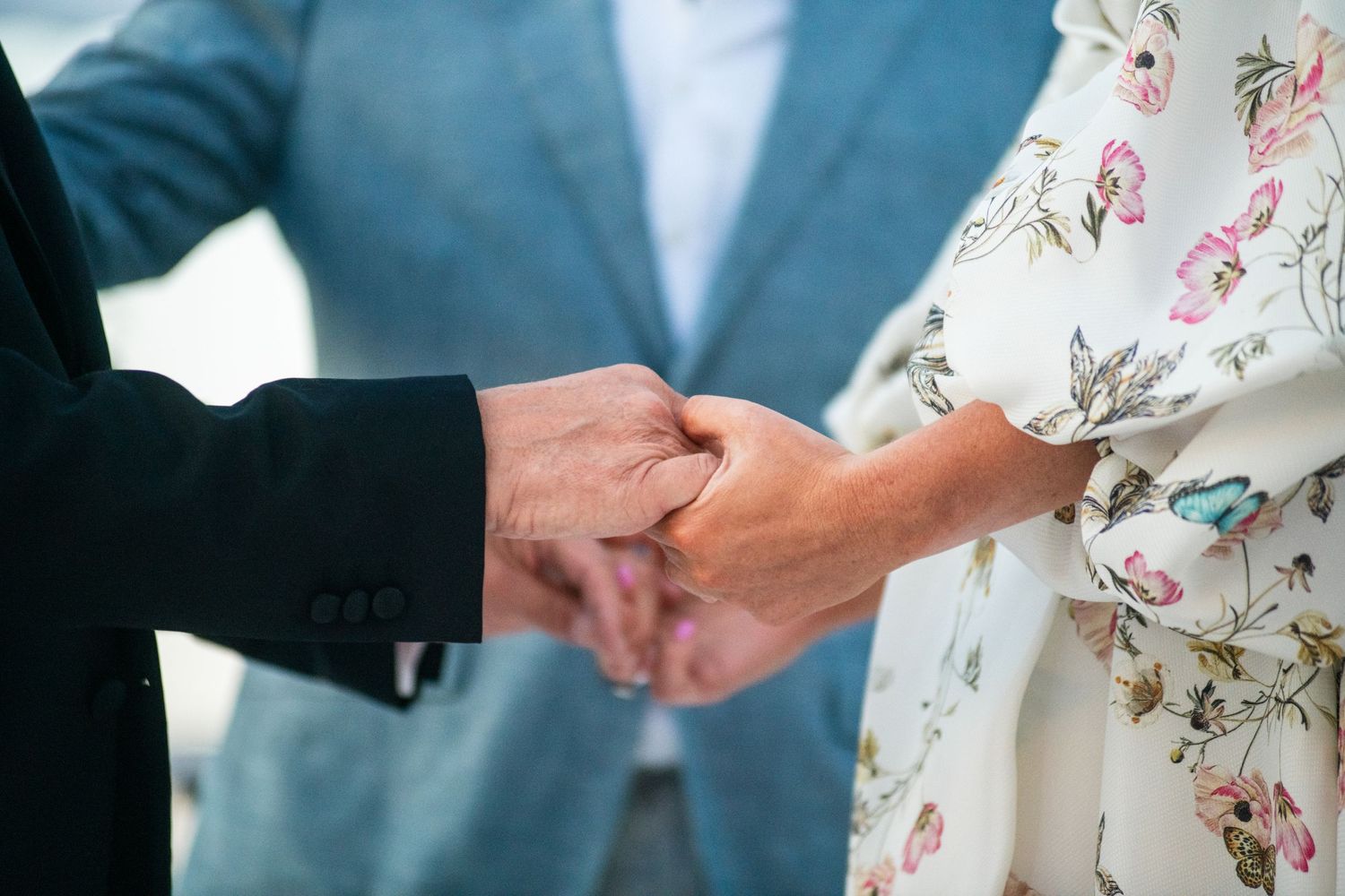 Close-up of hands exchanging rings during a wedding ceremony.