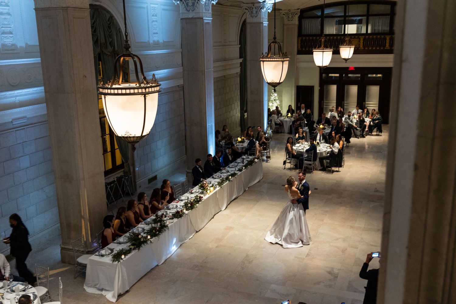 Birds-eye perspective of a formal event in a grand ballroom with couples dancing.