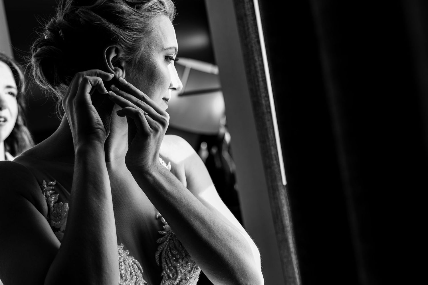 Black and white photo showing final wedding dress preparations.