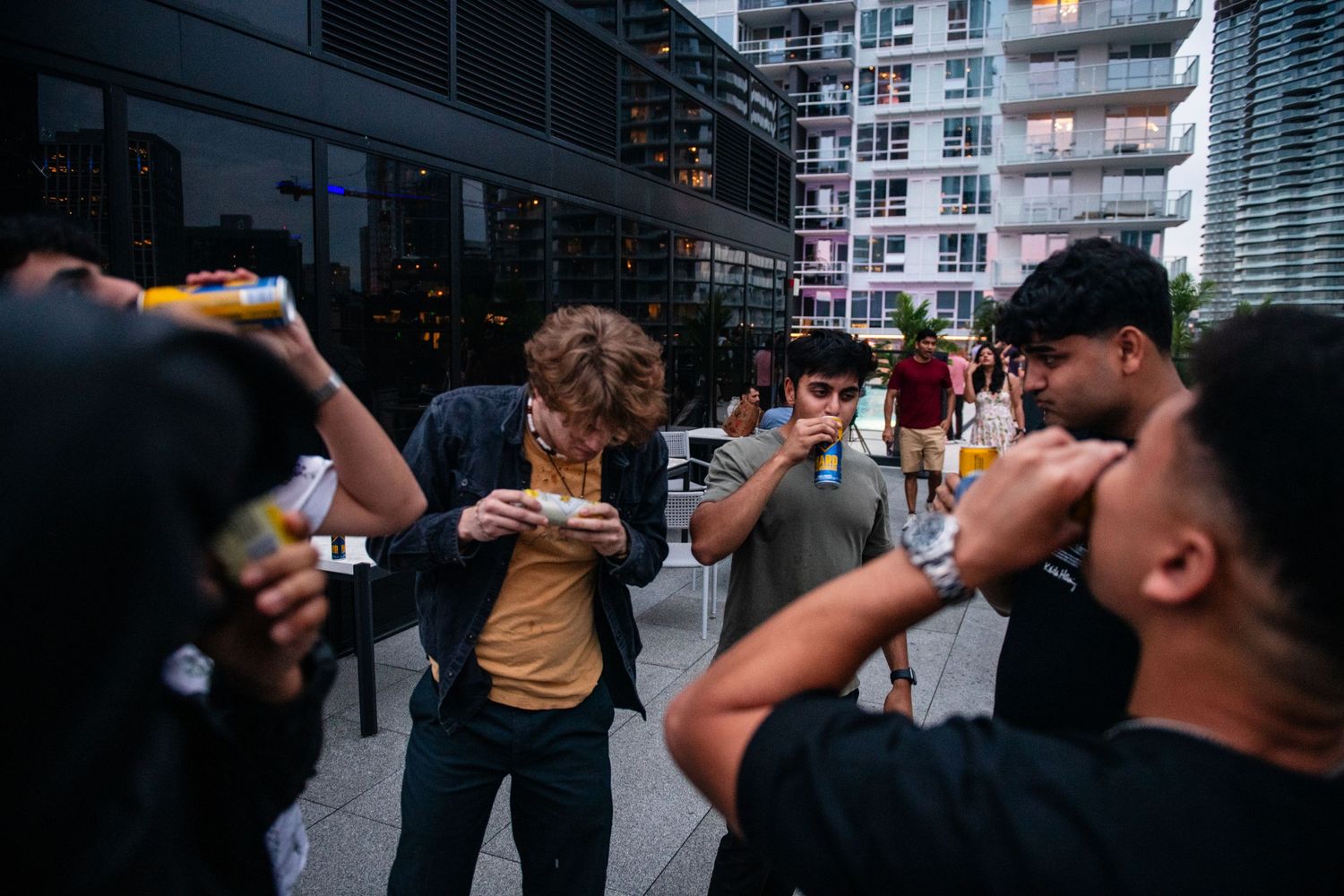 People drinking and socializing at an urban outdoor gathering.