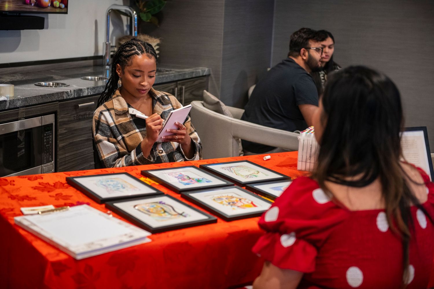 Person reviews menu items with customer at decorated table during event.