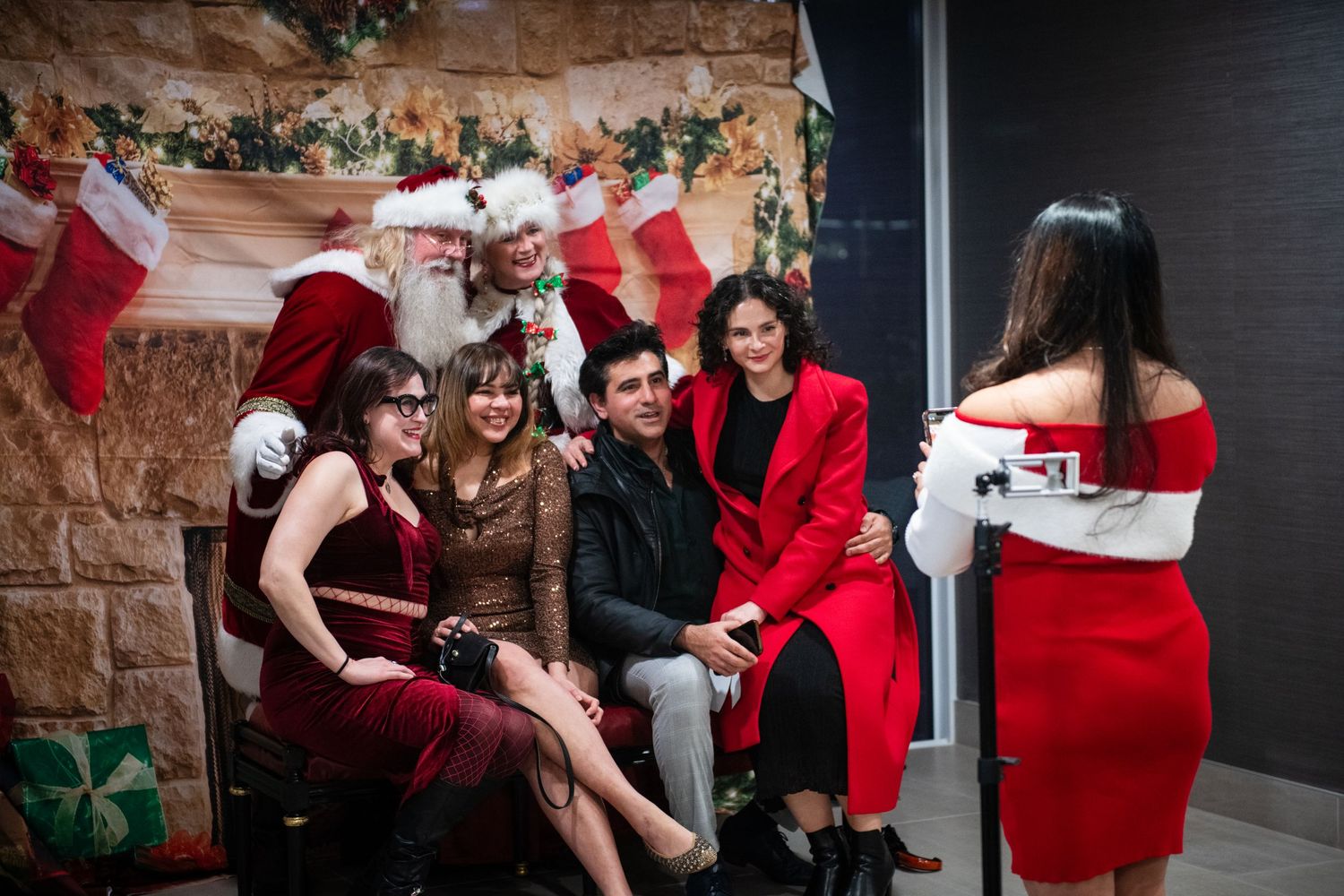 A group gathering at a holiday party with festive decor and red clothing.