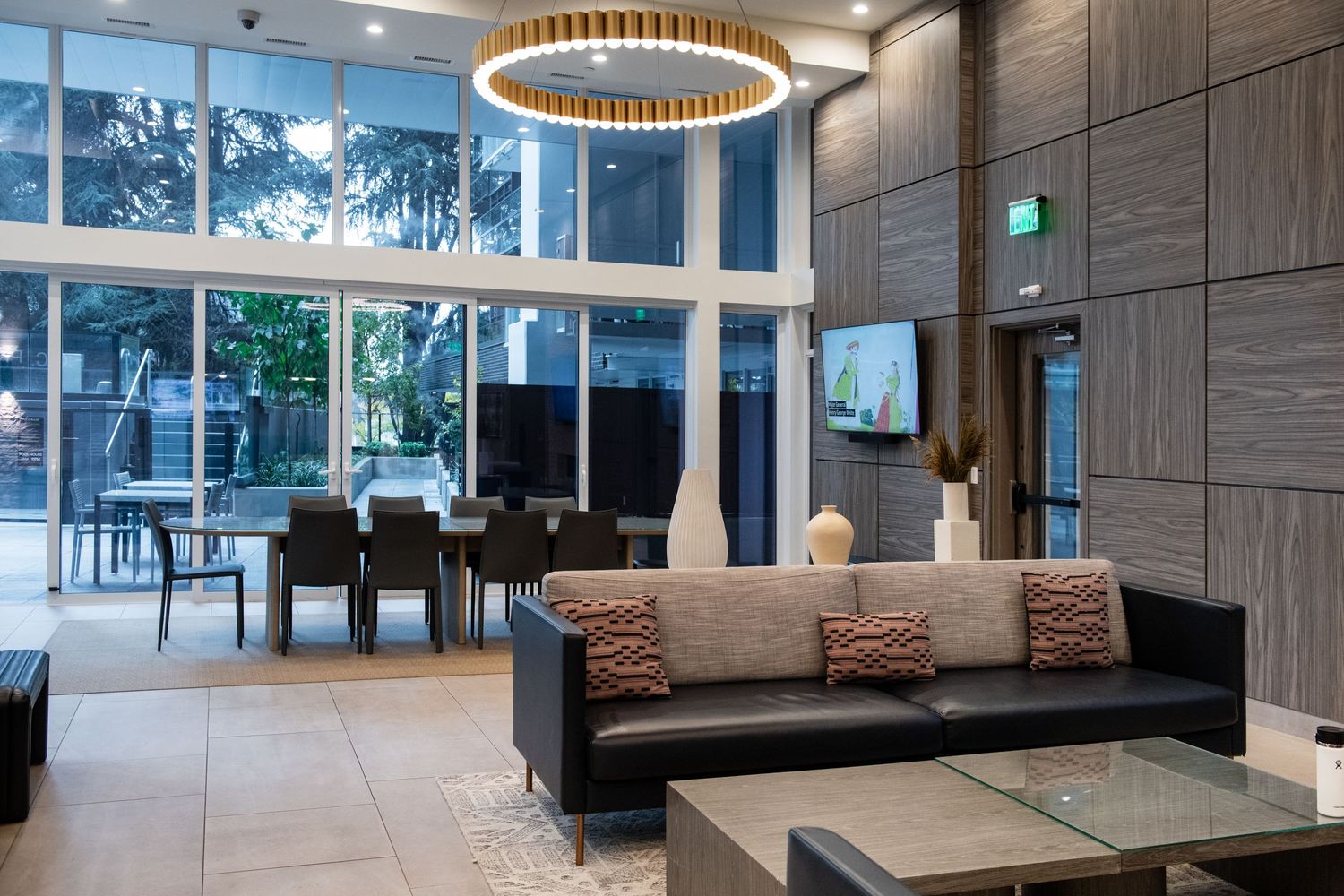 Contemporary lobby lounge area with high ceilings, modern furniture and circular pendant lighting.