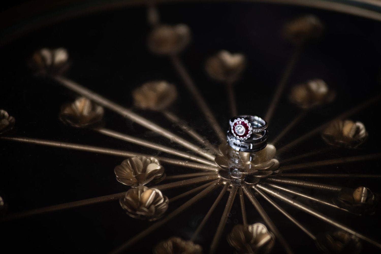 Elegant engagement ring photographed on a decorative metal starburst design.