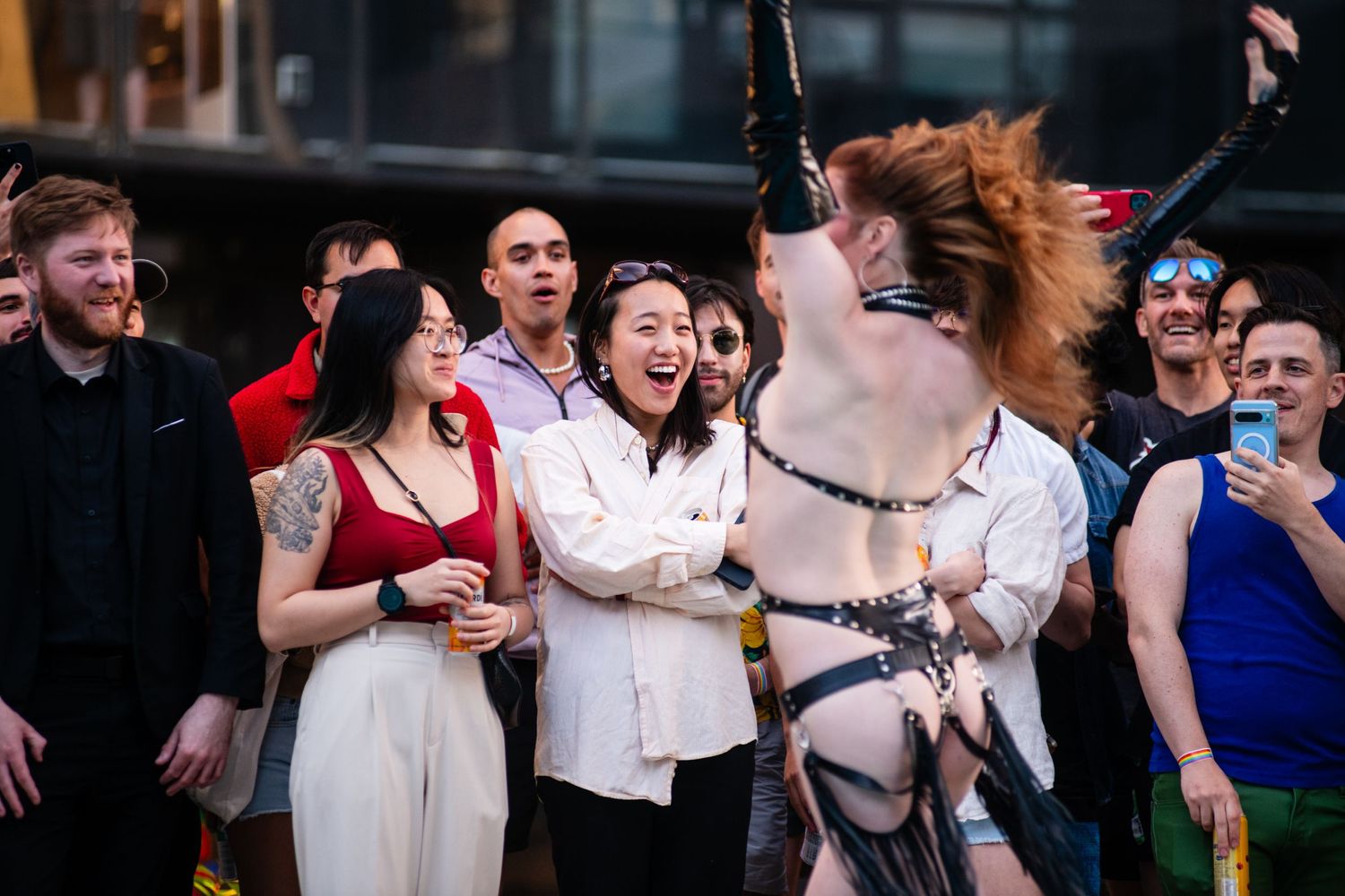 Crowd reacts excitedly to performers at an outdoor pool party event.
