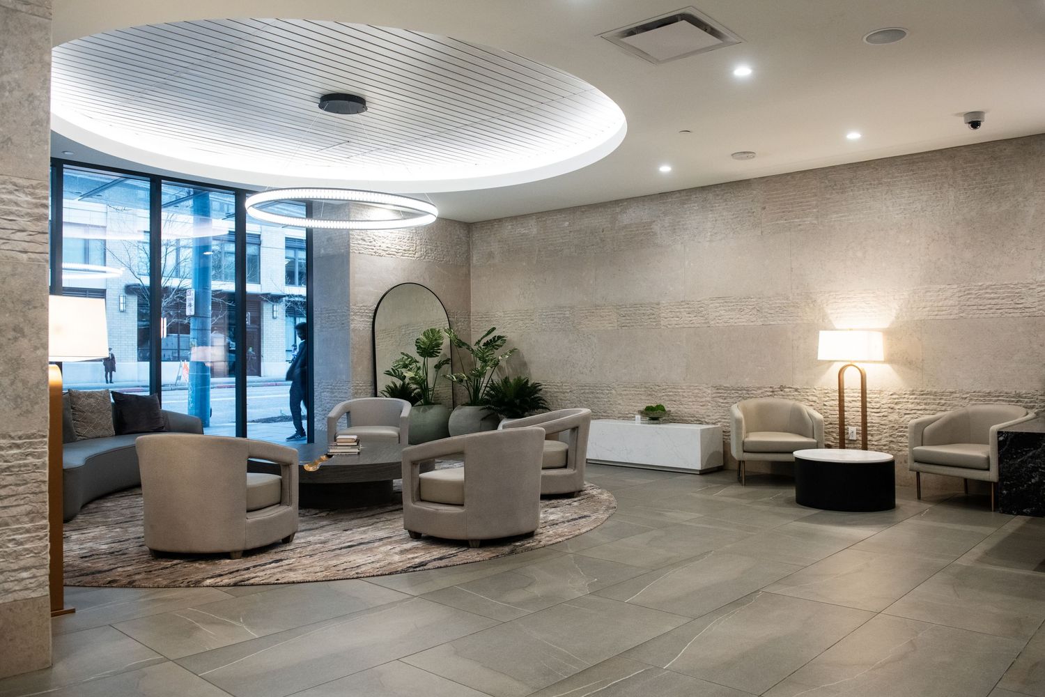Luxurious lobby lounge with curved ceiling detail, modern seating, and textured stone walls.