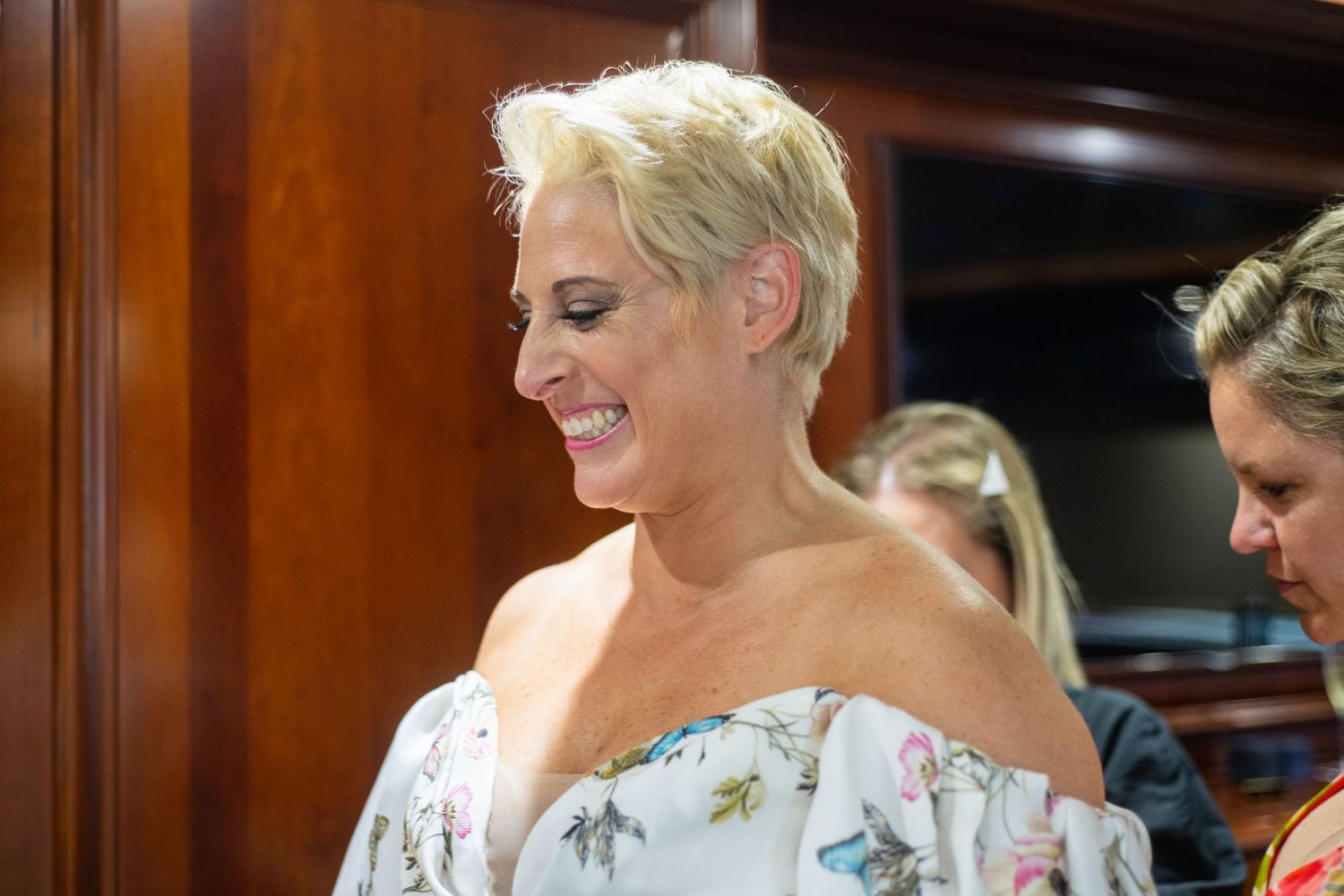 Close-up portrait showing joyful expression while wearing floral off-shoulder dress.