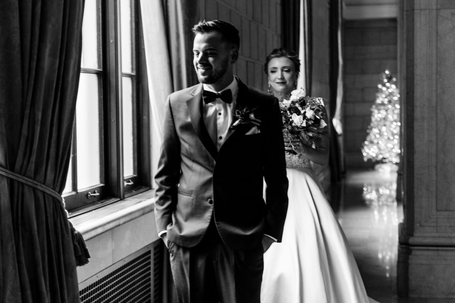 Elegant black and white wedding portrait in a classic interior with window light.