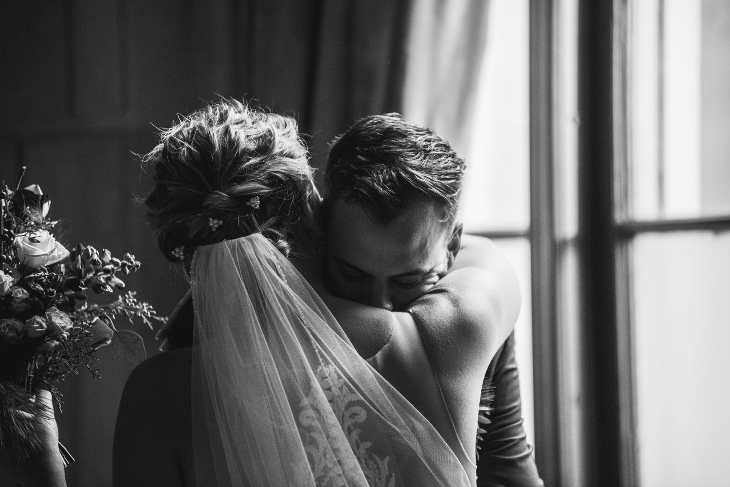 Intimate black and white portrait of wedding couple sharing a tender moment.