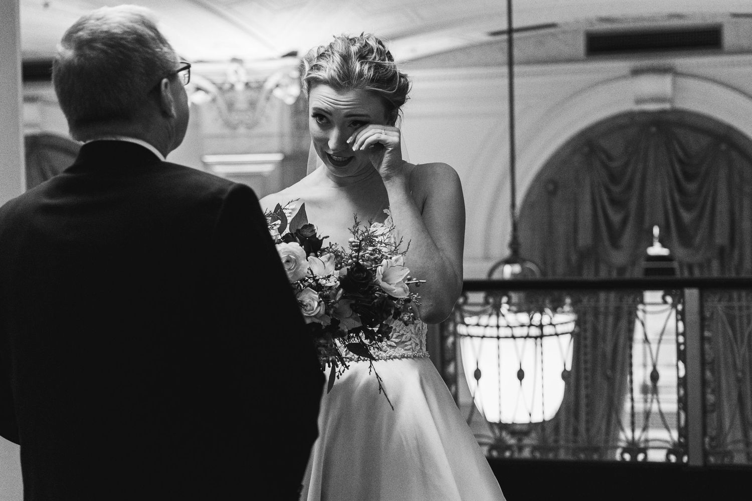 Black and white candid moment during wedding ceremony with emotional reaction.