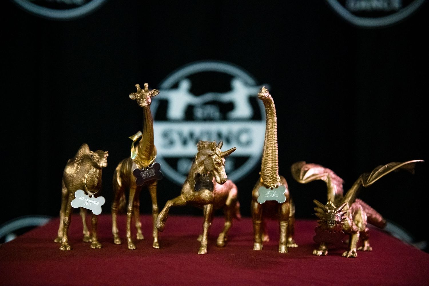 Collection of golden animal figurines displayed on red velvet surface.