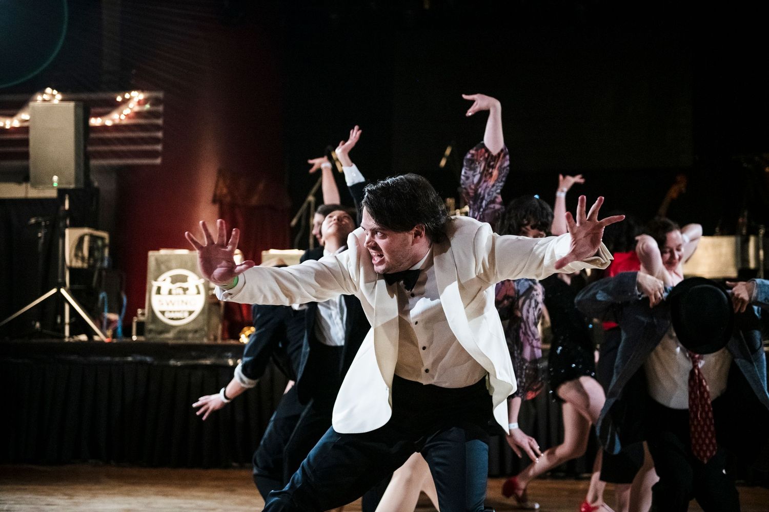 Energetic swing dancers perform dramatic poses during a choreographed routine.