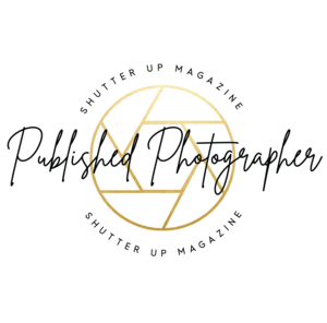 Minimalist gold camera lens aperture logo design on black background.