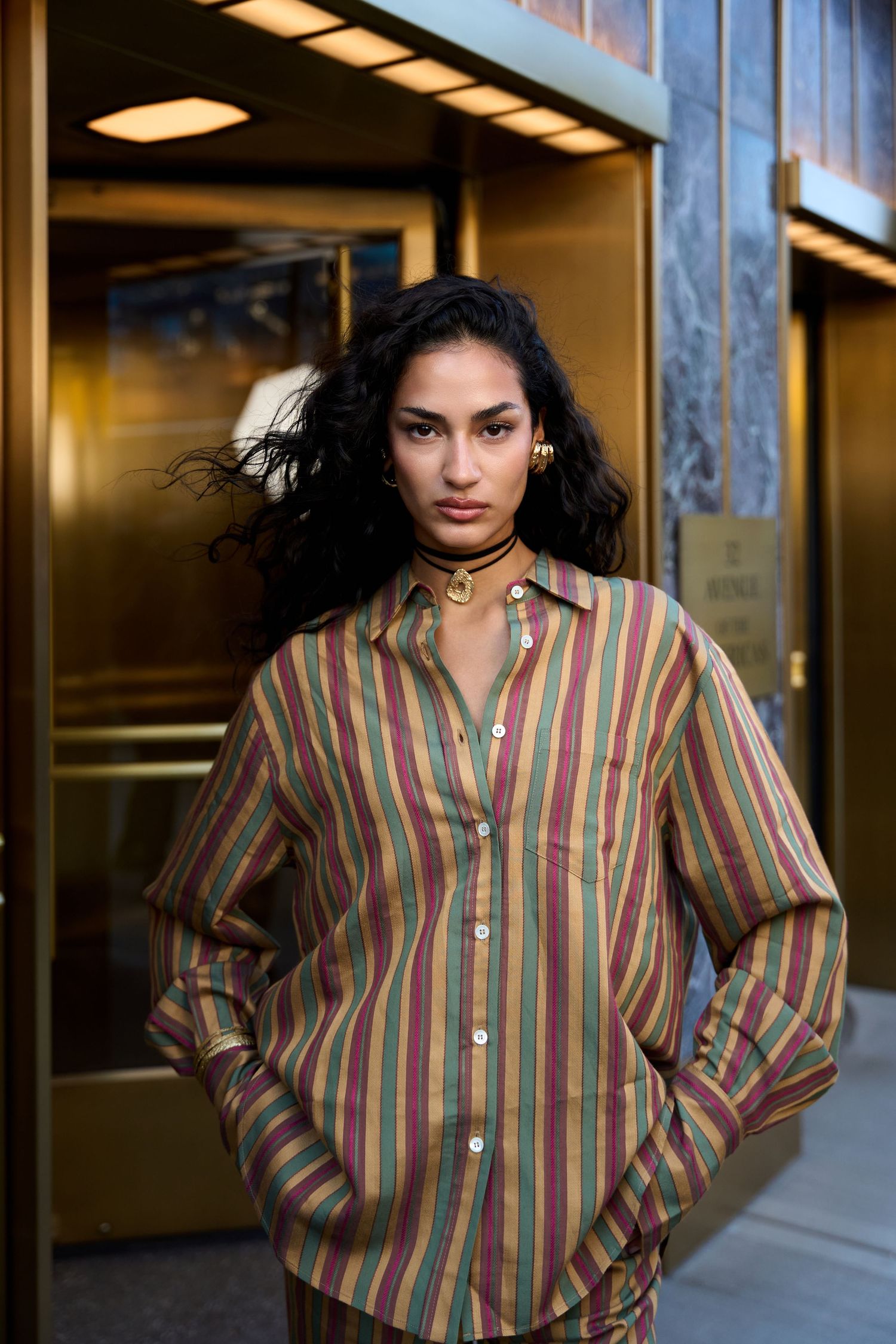 A series of fashion photos showing a striped button-up shirt in earth tones against an indoor background.