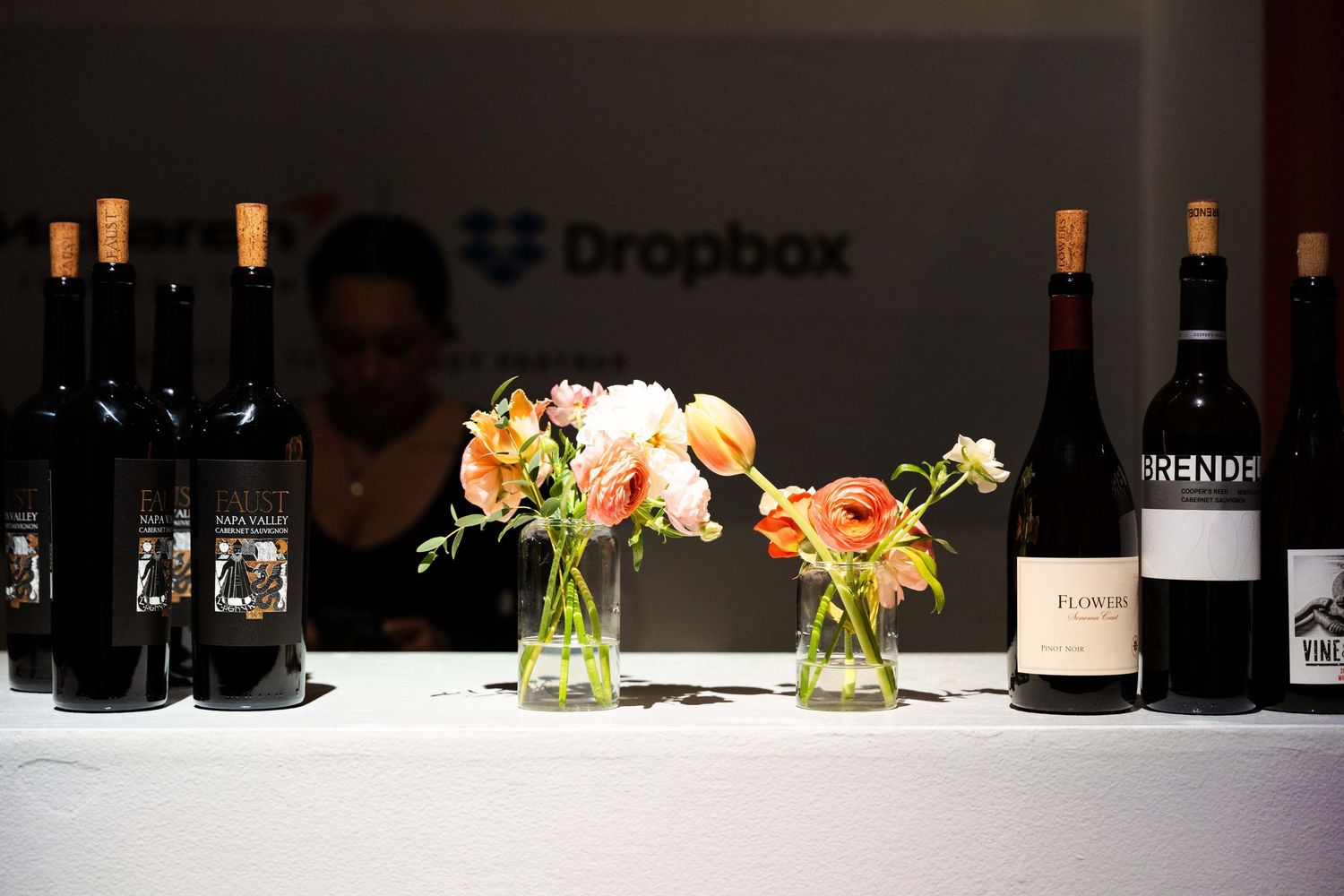 Wine bottles and floral centerpieces displayed at Dropbox branded event.