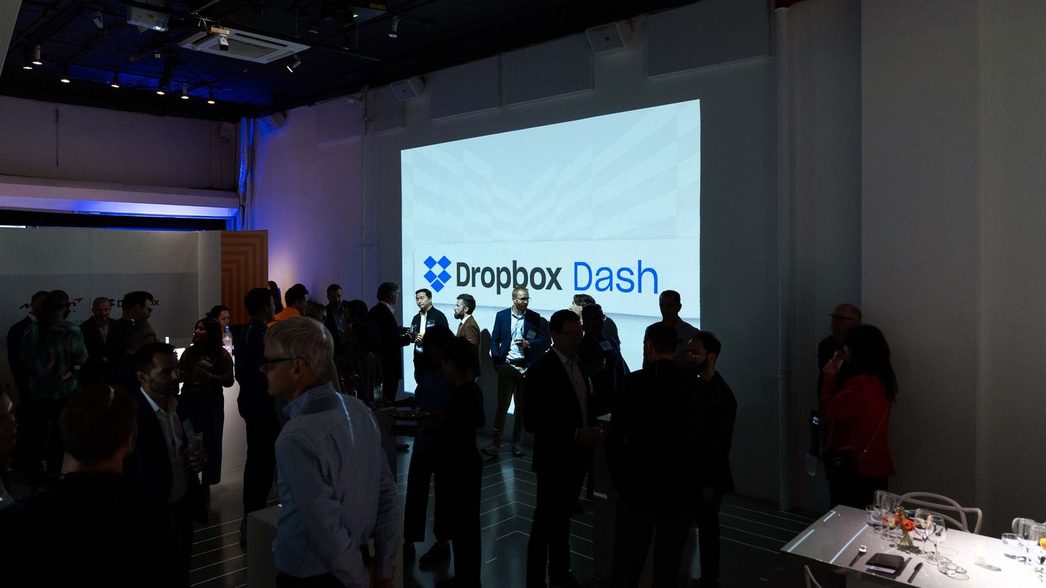 Dropbox Dash event presentation with audience silhouettes in a dimly lit room.