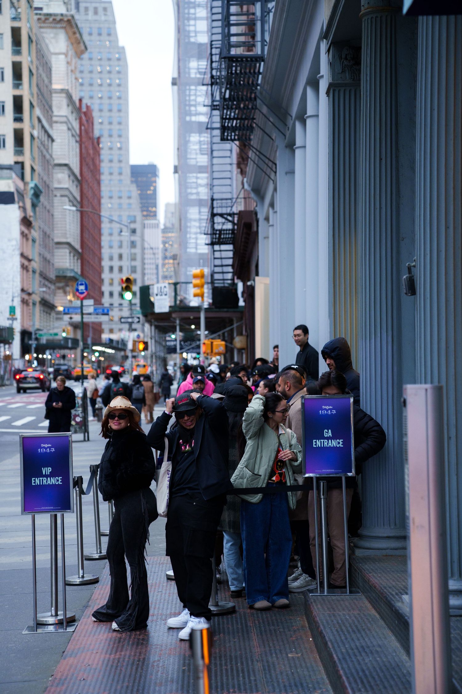 Line of people waiting outside a store entrance on a New York City street.